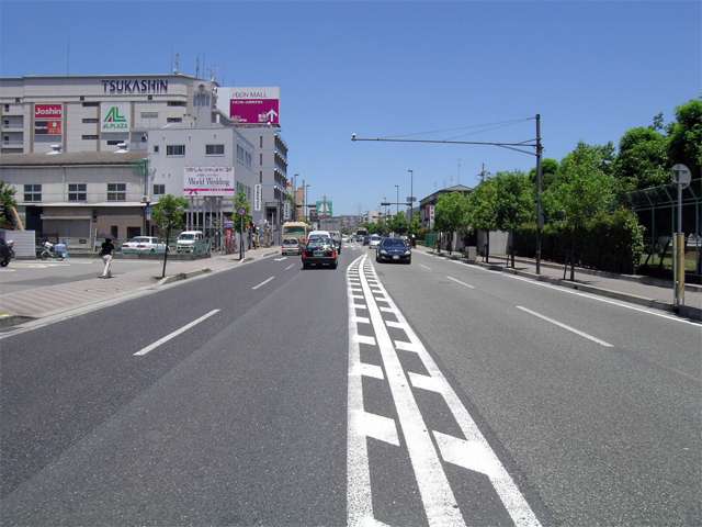 産業道路。道路沿いには飲食店や買物施設など、多くの商業施設が建ち並んでいます。