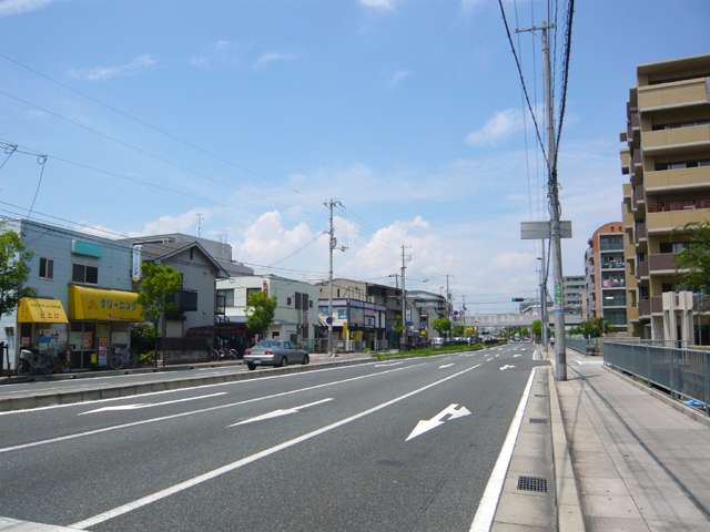 『東塚口町1丁目』付近の産業道路。道路沿いには様々な商業施設が並んでいます。