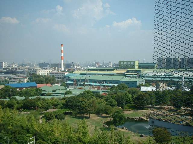 「阪神杭瀬」駅・「大物」駅南側の風景。敷地の広い緑豊かな公園と工場とが混在しています。