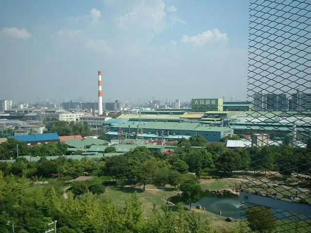 「阪神杭瀬」駅・「大物」駅南側の風景。敷地の広い緑豊かな公園と工場とが混在しています。