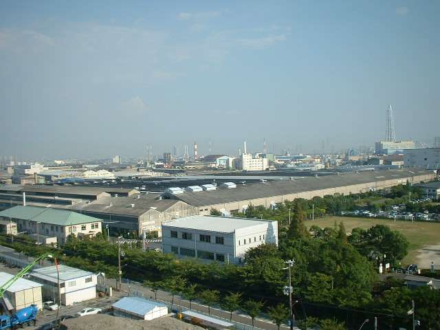 尼崎臨海エリアの遠景。工場内の木々や通りの街路樹から緑の潤いを感じられます。