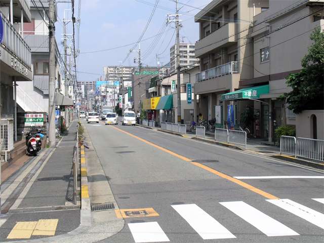 『姫室町、呉羽町』付近の伊丹池田線。道沿いには各種店舗が建ち並んでいます。