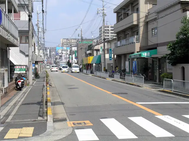『姫室町、呉羽町』付近の伊丹池田線。道沿いには各種店舗が建ち並んでいます。