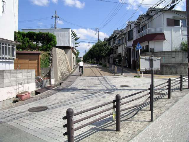 『萱野1丁目』の街並。旧道沿いは古い家もあり、落ち着いた雰囲気です。