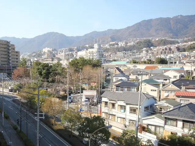 西岡本1丁目付近。ゆるやかな南斜面地に一戸建てとマンションが立ち並んでいます。