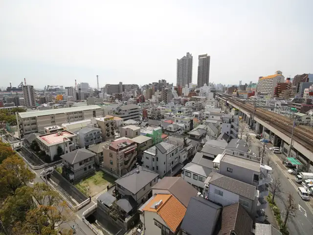 『深田町』周辺。前方に見えるJR「六甲道」駅前は賑やかで、高層住宅が立ち並んでいます。