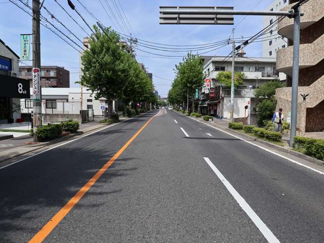地下鉄「本郷」駅からほど近い主要道路には店舗が並び、街路樹が多く見られます。