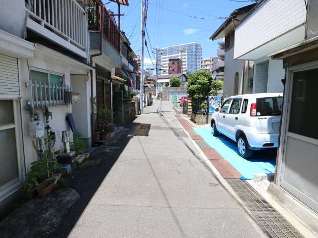 町に中央部を南東方向から見た景色。狭い街路沿いに一戸建てが並んでいますが、奥にはマンションが見えます。