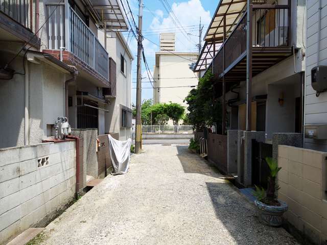 町の東部を南方向から見た景色。舗装されていない道路沿いに一戸建てが並んでいます。