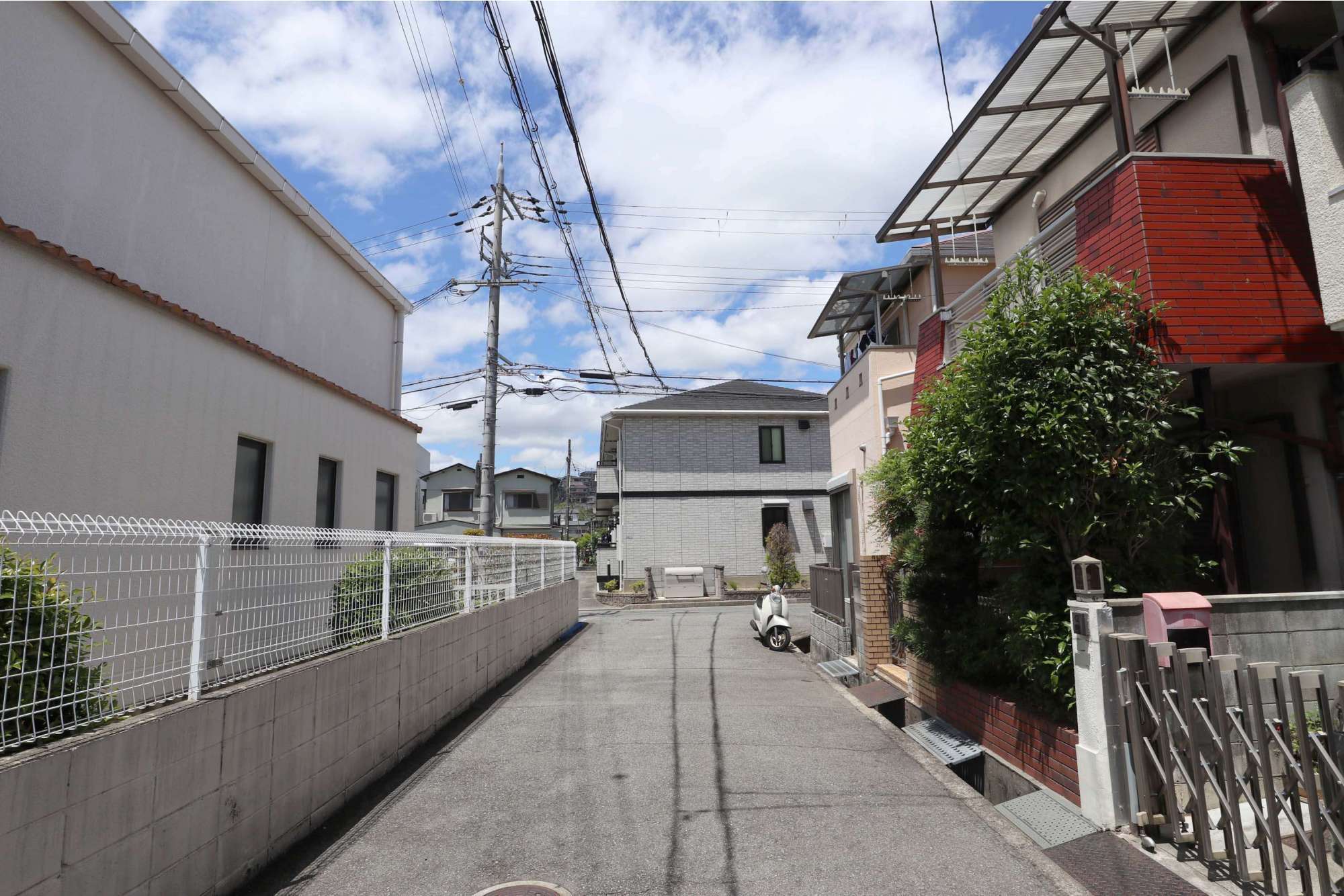 狭い街路沿いに一戸建てが多く立ち並んでいます。