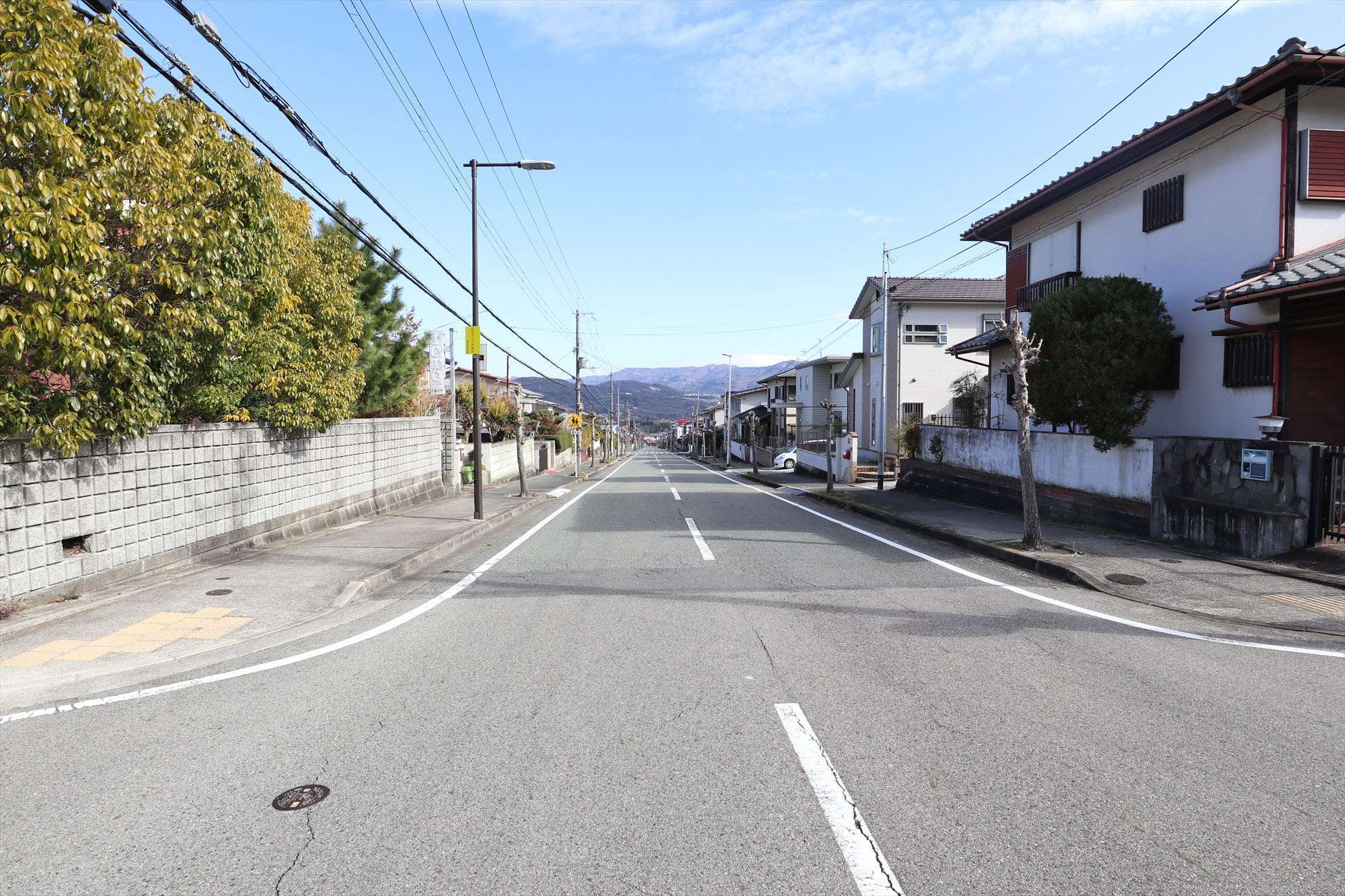 緩やかな下り坂になっています。奥には山々が見えます。