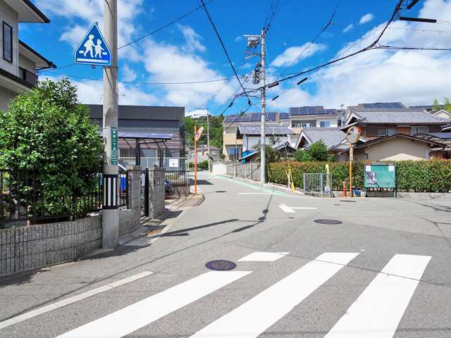 町の北西部を南方向から見た景色。生垣や植栽のある家が多く、周囲には緑地が多く残されています。