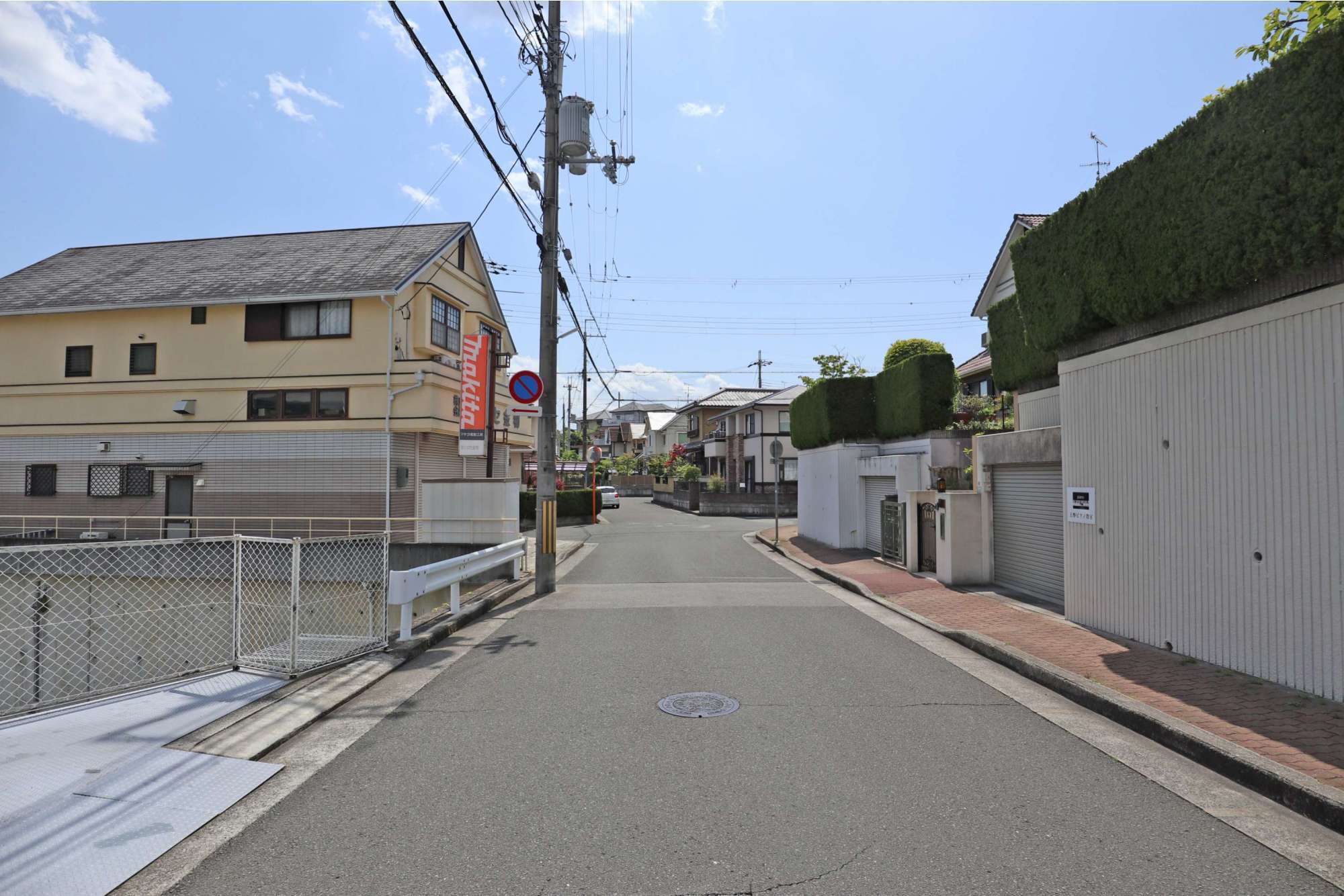 道路沿いに一戸建てが整然と立ち並ぶ住宅地です。
