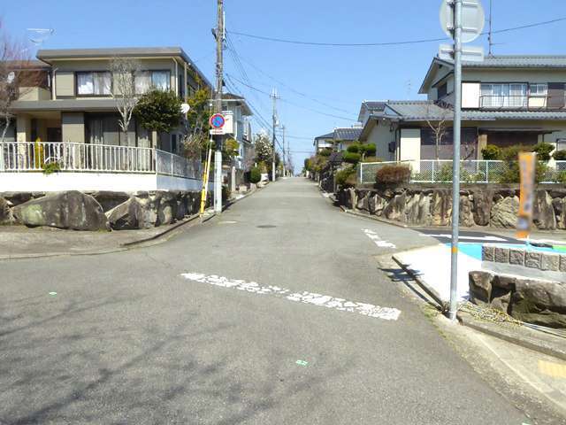 町の南西部を南方向から見た景色。生垣や植栽のある家が多く見られます。