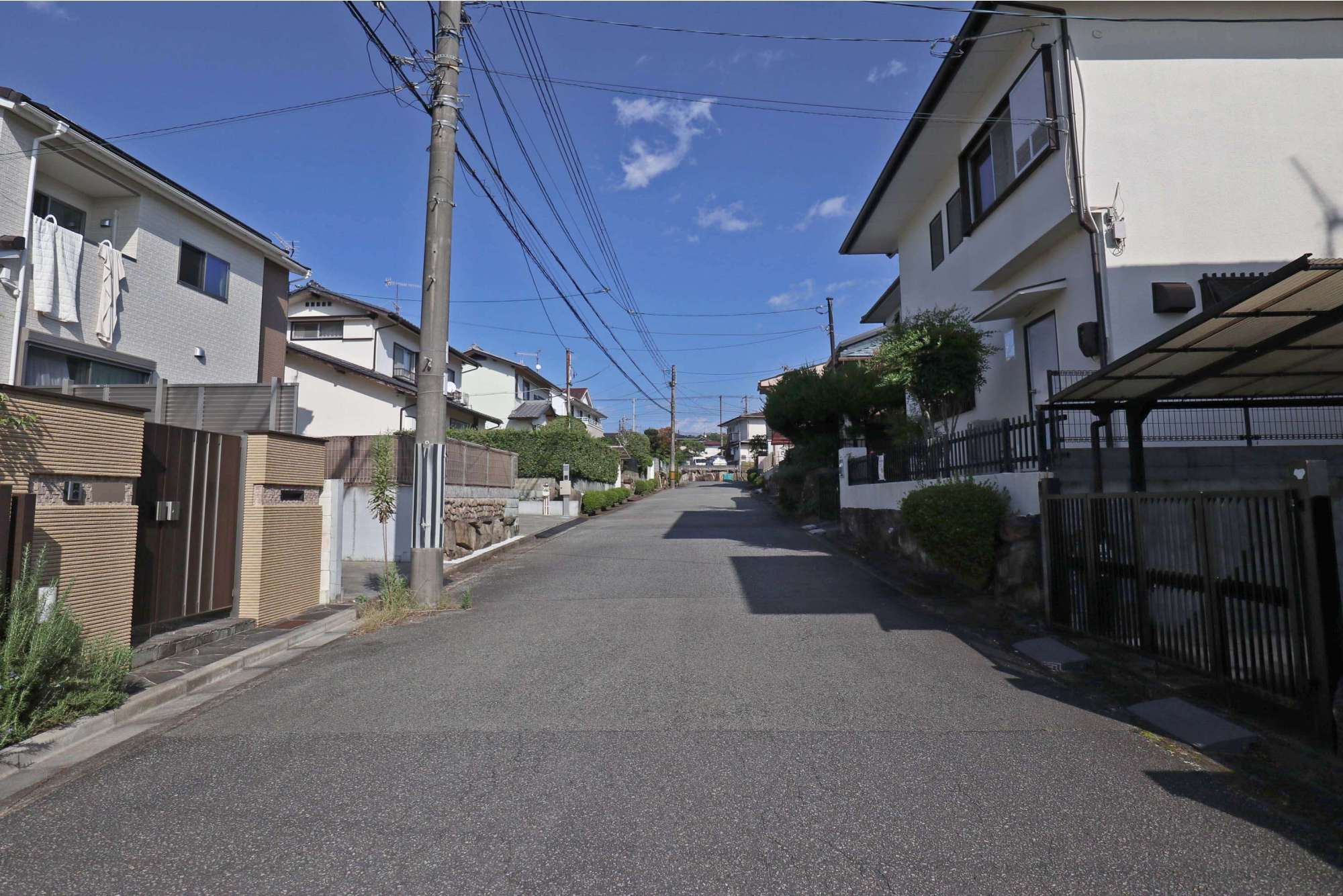 道幅の広い街路沿いに一戸建てが並んでいます。
