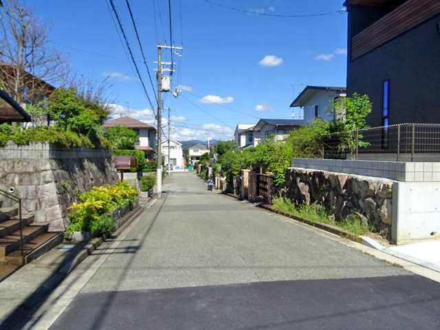 町の中央部を南方向から見た景色。生垣や植栽のある家が多く見られます。
