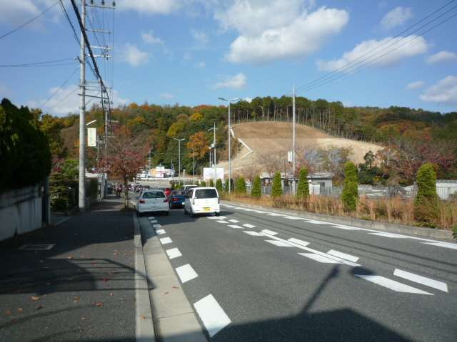 町の東端を南北に走る主要道路を南東方向から見た景色。近くの山林では今でも開発が進んでいます。