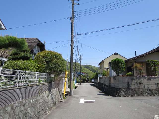 町の北西部を西方向から見た景色。住宅地の周辺には山林が広がっています。