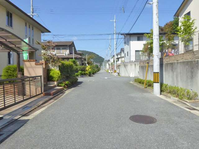 町の東部を南方向から見た景色。敷地の広い一戸建てが整然と並んでいます。奥には山林も見えています。