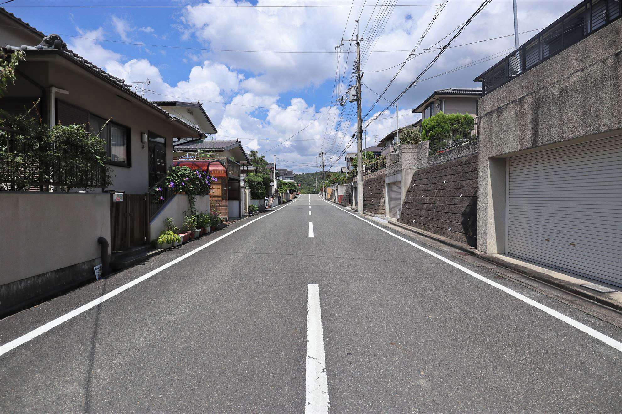 広い道路沿いに、敷地の広い一戸建てが並んでいます。
