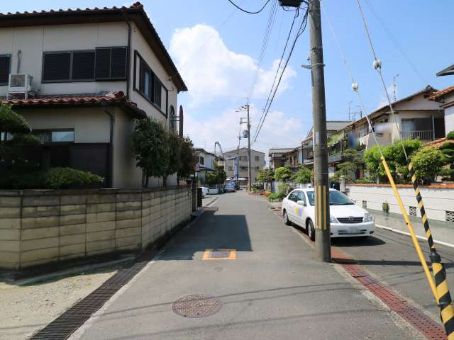 町の中央部を東側から見た景色。一戸建てやマンションなどが混在しています。