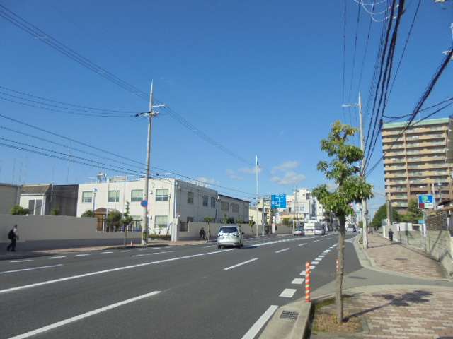 町の西側を走る産業道路。道路沿いには飲食店や買物施設など、多くの商業施設が建ち並んでいます。