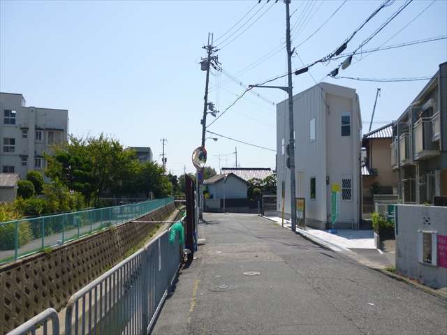 町の南東部を北方向から見た景色。左側を流れる小川の左側は鈴原町4丁目となります。