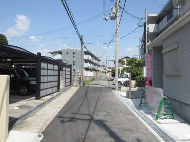 町の北部を西方向から見た景色。狭い道路沿いに一戸建てやマンションが並んでいます。