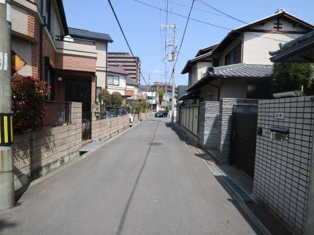 町の北部を南西方向から見た景色。直線的な街路沿いに生垣や植栽のある一戸建てが並んでいます。