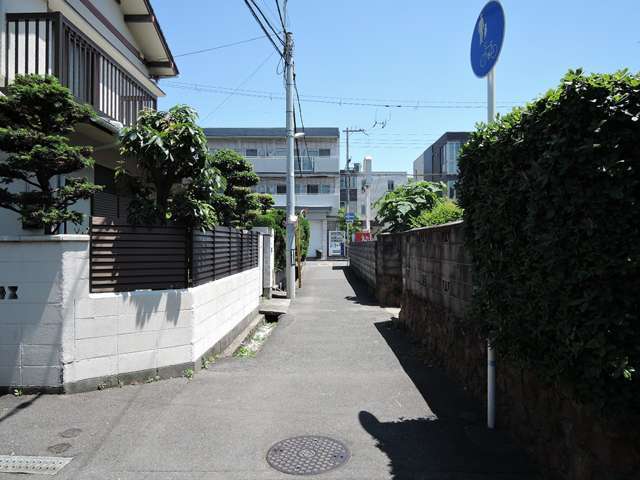 町の中央部を西方向から見た景色。狭い街路沿いに一戸建てやマンションなどが建っています。