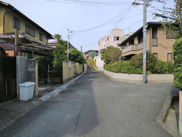 駅からの道のりはゆるやかな坂道、道幅はやや狭く、入り組んだ街並み。