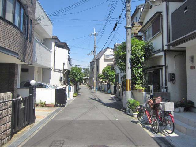 町の中央部を西方向から見た景色。狭い道路沿いに一戸建てが並んでいます。