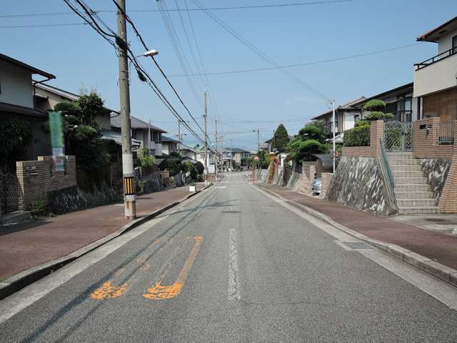 町の南西部を東方向から見た景色。道幅が広く、道路の両側に歩道が整備されています。