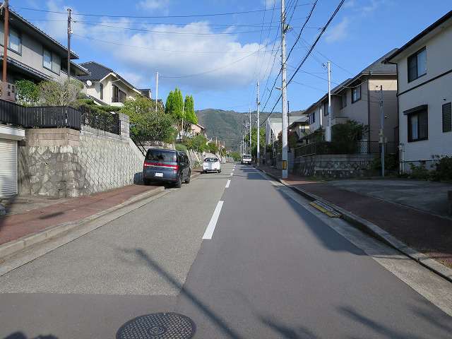 町の北西部を西方向から見た景色。道幅が広く区画の整った街路沿いに一戸建てが並んでいます。