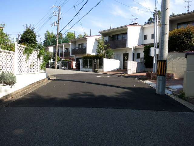 町の北東部を西方向から見た景色。生垣や植栽のある一戸建てが並んでいます。