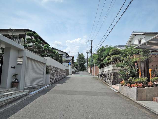 町の北東部を南方向から見た景色。勾配が緩やかな坂道沿いに一戸建てが並んでいます。