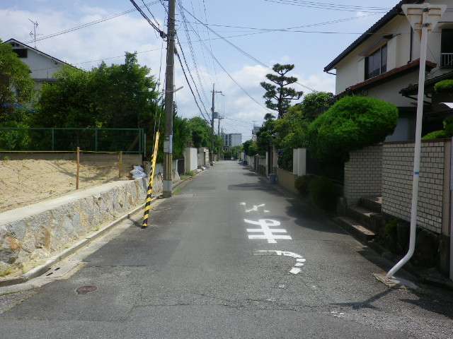 町の中央部を西方向から見た景色。生垣や植栽のある家が多く見られます。