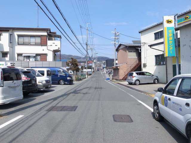 町の西部を南方向から見た景色。一戸建てやアパート、倉庫などが並んでいます。