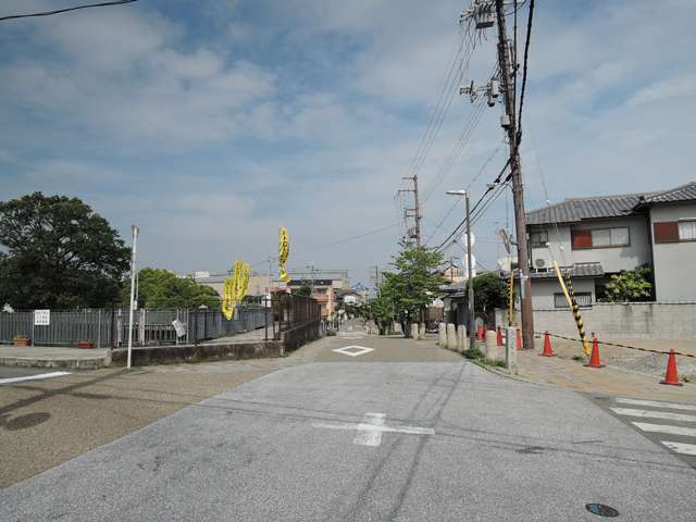町の北部を西方向から見た景色。奥へ延びる道路は箕面地区と萱野地区を結ぶ街道で、道標も設置されています。