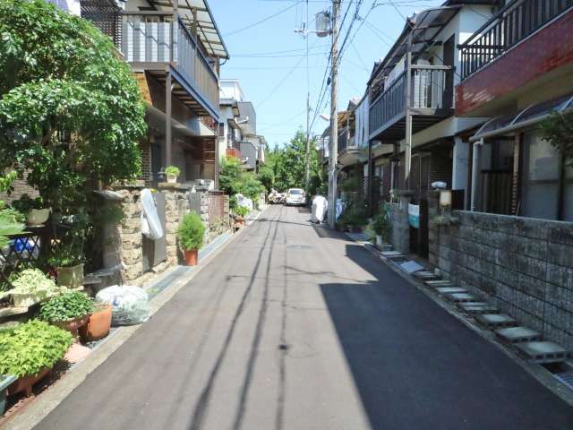 町の南東部を南方向から見た景色。生垣や植栽のある家が多く、緑豊かな街並みです。