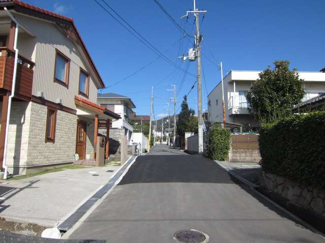 町の中央部を南方向から見た景色。北に向かうにつれて上り坂となり、奥には箕面の山々が見えます。