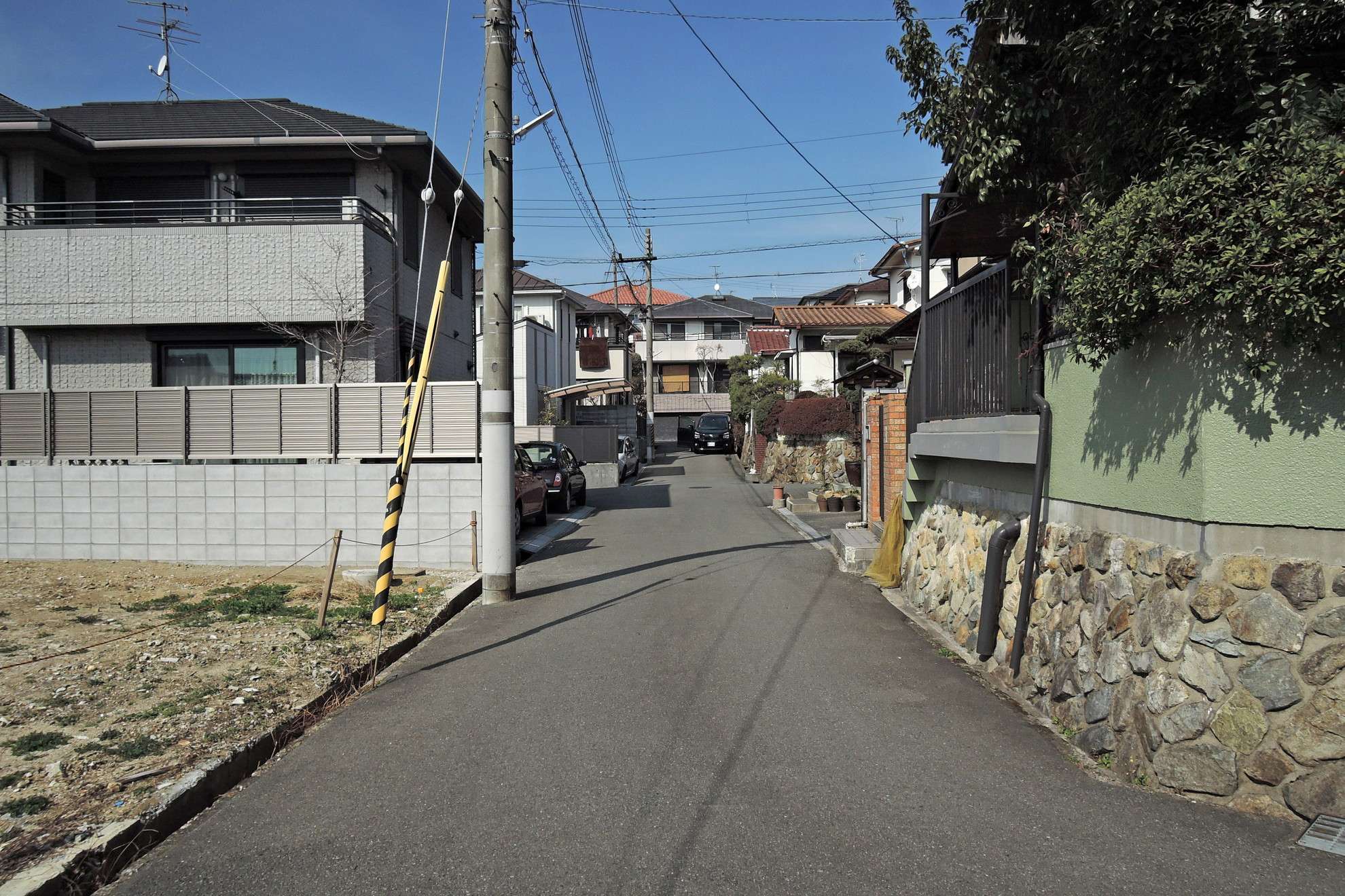 町の北部を南方向から見た景色。道幅が狭い街路沿いに一戸建てが並んでいます。