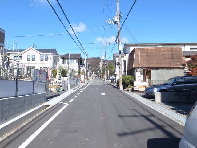 町の南部を南方向から見た景色。緩やかな上り坂が続いています。奥には箕面の山々が見えます。