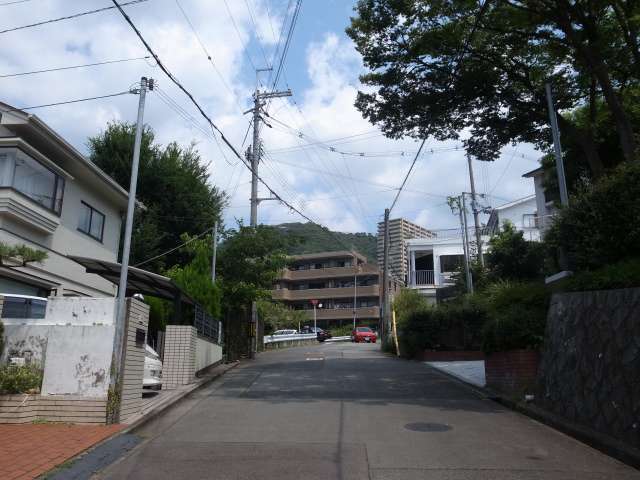 町の南東部を南方向から見た景色。急な坂道沿いに一戸建てやマンションが並んでいます。