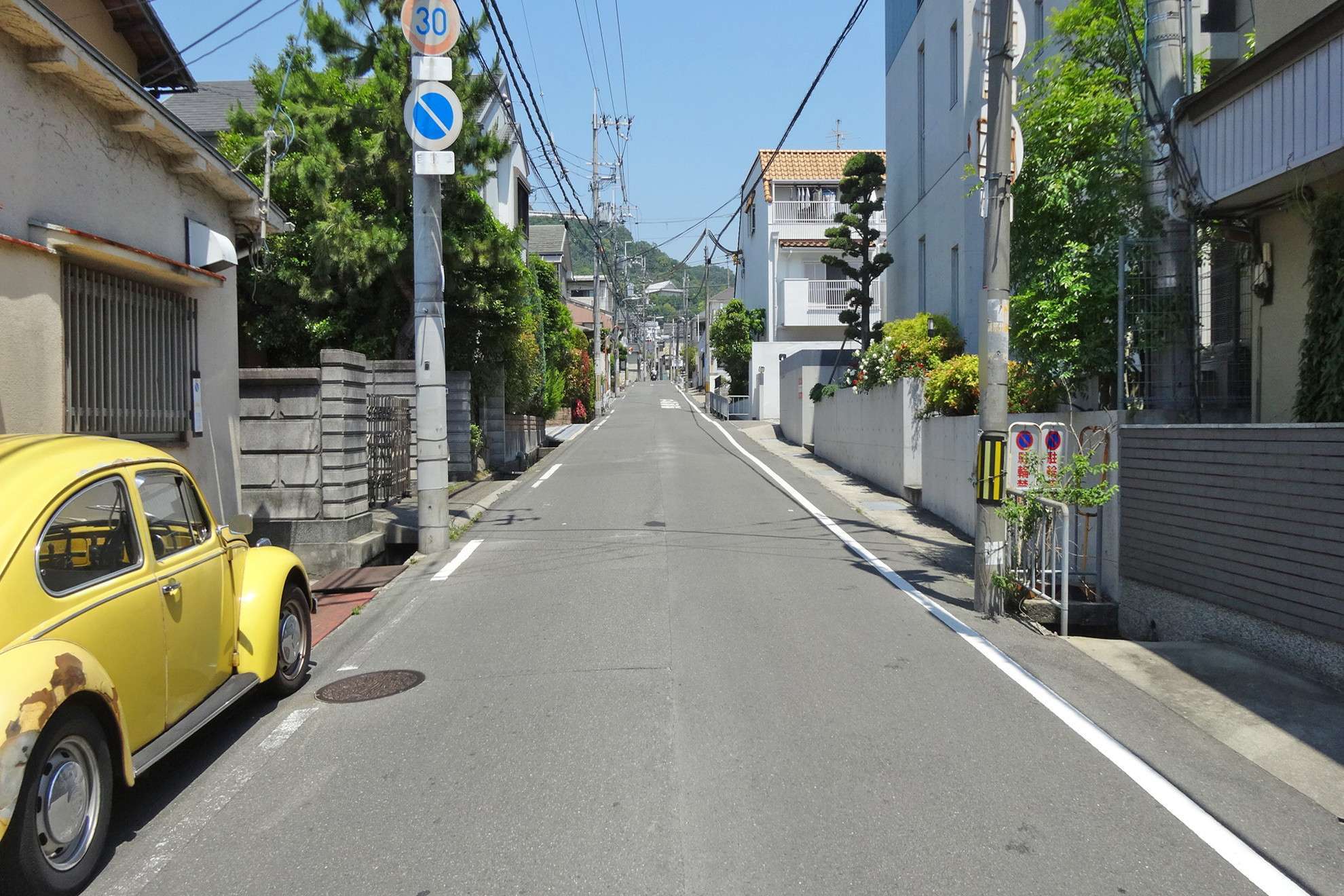 町の北部を南方向から見た景色。奥に見える箕面の山々に向けて緩やかな上り坂が続きます。