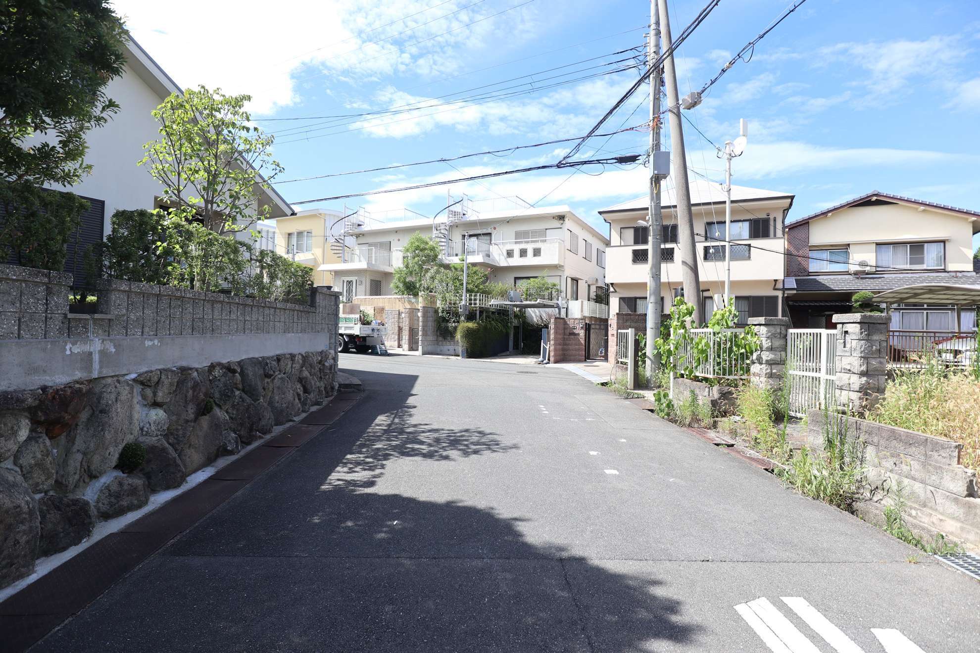 道幅が広い街路沿いに敷地の広い一戸建てが並んでいます。