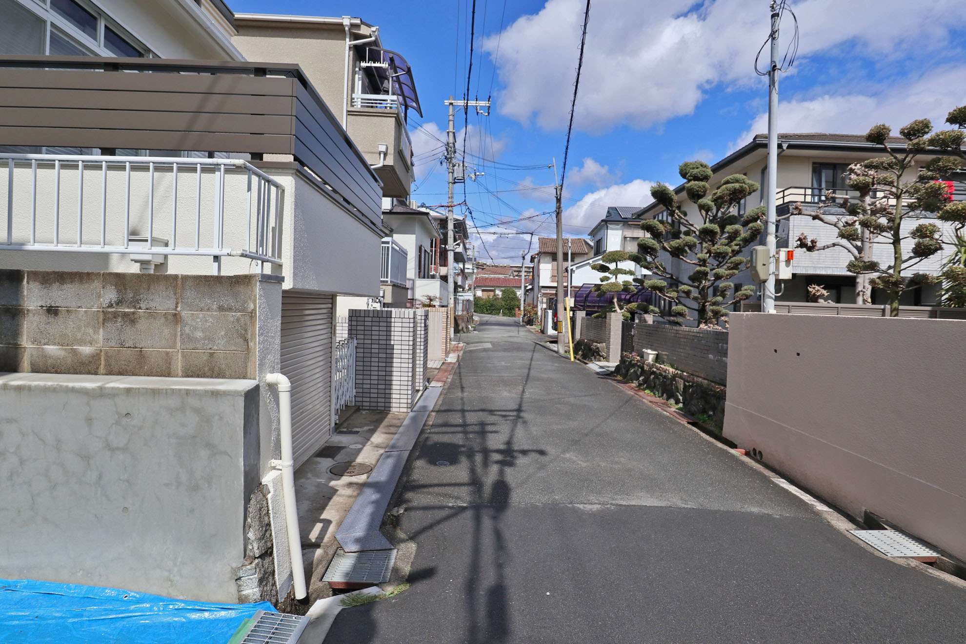 町の北部を南方向から見た景色。一戸建てが多く並んでいますが、奥には高層のマンションが見えます。