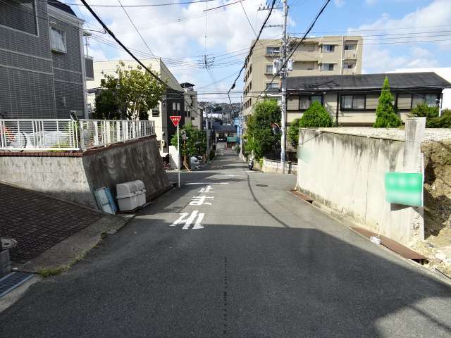 的の南西部を東方向から見た景色。斜面地に一戸建てやマンションなどが並んでいます。