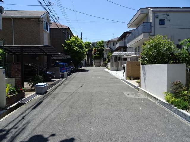 町の南部を北方向から見た景色。生垣や植栽のある家が多く、緑豊かな住環境です。