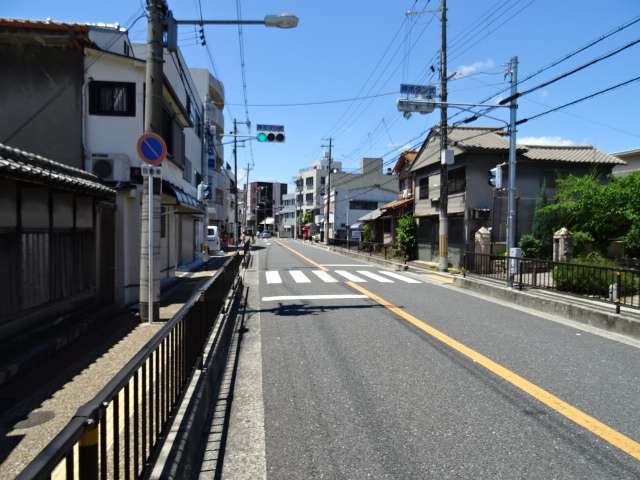 町の南端を通る府道151号相川停車場線。一戸建てやマンションンなどが混在しています。